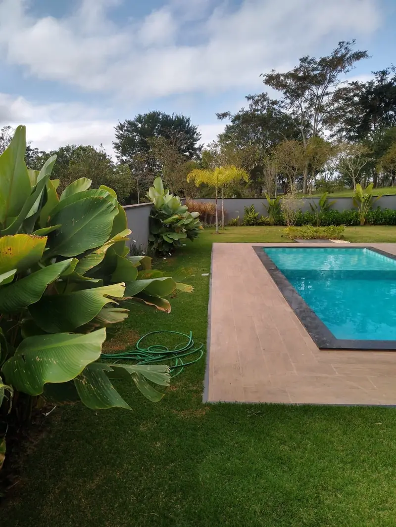 Piscina com deck e jardim tropical